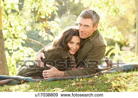 Stock Photo - Romantic Couple Relaxing Outdoors In Autumn Landscape. Fotosearch