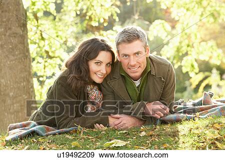 Stock Photo - Romantic Couple Relaxing Outdoors In Autumn Landscape. Fotosearch