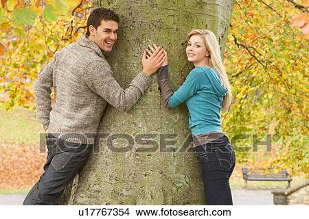 Romantic Teenage Couple By Tree In Autumn Park View Large Photo Image Picture - Romantic Teenage Couple By Tree In Autumn Park. Fotosearch