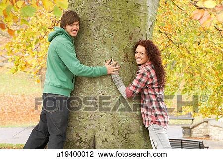 Romantic Teenage Couple By Tree In Autumn Park View Large Photo Image Stock Image - Romantic Teenage Couple By Tree In Autumn Park. Fotosearch