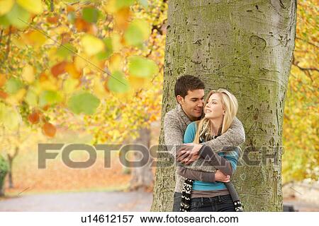 Romantic Teenage Couple By Tree In Autumn Park View Large Photo Image Stock Photo - Romantic Teenage Couple By Tree In Autumn Park. Fotosearch