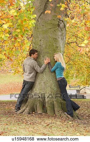 Romantic Teenage Couple By Tree In Autumn Park View Large Photo Image Stock Photo - Romantic Teenage Couple By Tree In Autumn Park. Fotosearch