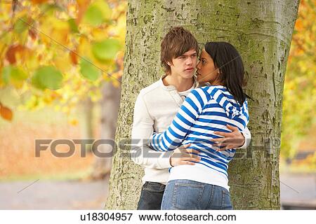 Romantic Teenage Couple By Tree In Autumn Park View Large Photo Image Stock Photo - Romantic Teenage Couple By Tree In Autumn Park. Fotosearch
