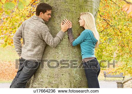 Stock Photograph - Romantic Teenage Couple By Tree In Autumn Park. Fotosearch