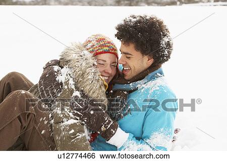 Stock Photograph - Romantic Teenage Couple Having Fun In Snow. Fotosearch