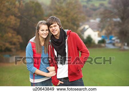 Stock Photo - Romantic Teenage Couple Walking Through Autumn Landscape. Fotosearch