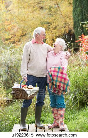 Senior Couple Outdoors With Picnic Basket By Autumn Woodland View Large Photo Image Stock Photography - Senior Couple Outdoors With Picnic Basket By Autumn Woodland. Fotosearch
