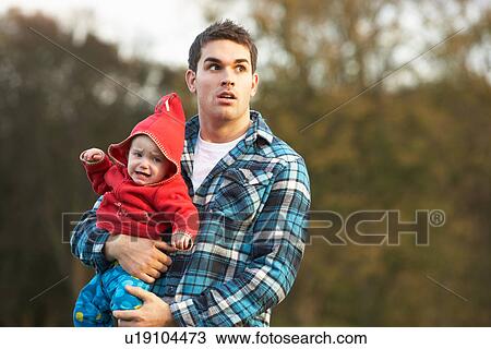 Stock Image - Shocked Teenage Boy Holding Baby. Fotosearch