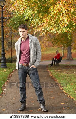 Teenage Boy Standing In Autumn Park With Female Figure On Bench In Background View Large Photo Image Stock Photo - Teenage Boy Standing In Autumn Park With Female Figure On Bench In Background. Fotosearch