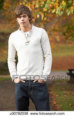 Stock Photo - Teenage Boy Standing In Autumn Park. Fotosearch