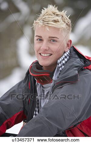 Stock Image - Teenage Boy Wearing Winter Clothes In Snowy Landscape. Fotosearch
