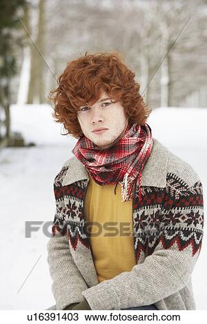 Stock Image - Teenage Boy Wearing Winter Clothes In Snowy Landscape. Fotosearch