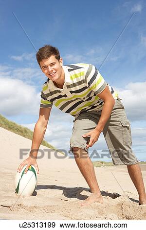 Teenage Boy With Rugby Ball On Beach View Large Photo Image Stock Photo - Teenage Boy With Rugby Ball On Beach. Fotosearch