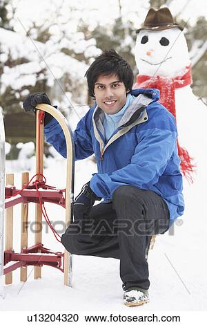 Teenage Boy With Sledge Next To Snowman View Large Photo Image Stock Image - Teenage Boy With Sledge Next To Snowman. Fotosearch