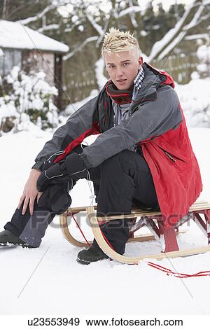 Teenage Boy With Sledge Next To Snowman View Large Photo Image Stock Photo - Teenage Boy With Sledge Next To Snowman. Fotosearch