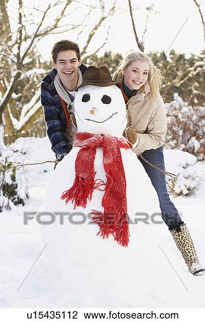 Teenage Couple Building Snowman View Large Photo Image Stock Image - Teenage Couple Building Snowman. Fotosearch
