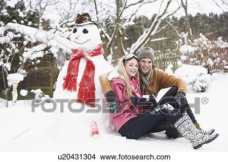 Teenage Couple In Winter Landscape Next To Snowman With Flask And Hot Drink View Large Photo Image Picture - Teenage Couple In Winter Landscape Next To Snowman With Flask And Hot Drink. Fotosearch