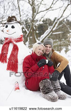 Teenage Couple In Winter Landscape Next To Snowman With Flask And Hot Drink View Large Photo Image Stock Image - Teenage Couple In Winter Landscape Next To Snowman With Flask And Hot Drink. Fotosearch