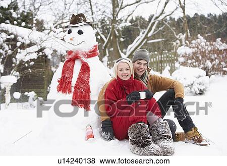 Teenage Couple In Winter Landscape Next To Snowman With Flask And Hot Drink View Large Photo Image Stock Photo - Teenage Couple In Winter Landscape Next To Snowman With Flask And Hot Drink. Fotosearch