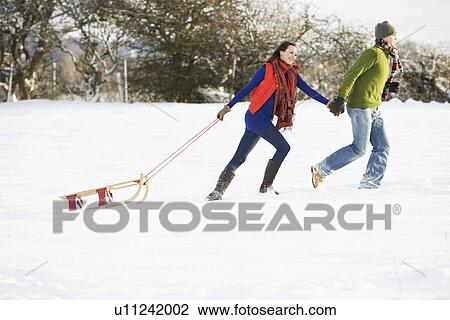 Teenage Couple Pulling Sledge Across Snowy Field View Large Photo Image Stock Image - Teenage Couple Pulling Sledge Across Snowy Field. Fotosearch