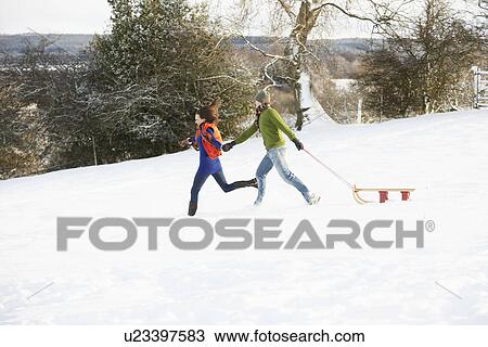 Teenage Couple Pulling Sledge Across Snowy Field View Large Photo Image Stock Image - Teenage Couple Pulling Sledge Across Snowy Field. Fotosearch
