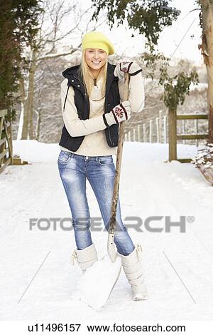 Stock Photo - Teenage Girl Clearing Snow From Drive. Fotosearch