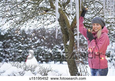 Teenage Girl Hanging Fairy Lights In Tree With Icicles In Foreground View Large Photo Image Stock Image - Teenage Girl Hanging Fairy Lights In Tree With Icicles In Foreground. Fotosearch