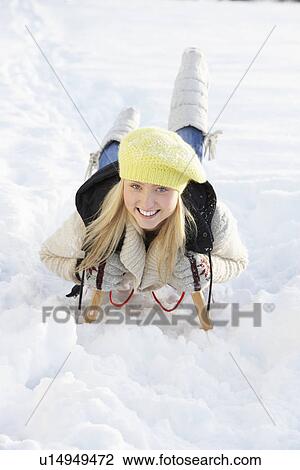 Stock Image - Teenage Girl Riding On Sledge In Snowy Landscape. Fotosearch