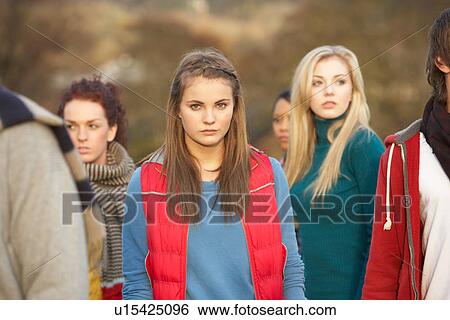 Stock Photograph - Teenage Girl Surrounded By Friends In Outdoor Autumn Landscape. Fotosearch