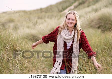 Teenage Girl Walking Through Sand Dunes Wearing Warm Clothing View Large Photo Image Stock Image - Teenage Girl Walking Through Sand Dunes Wearing Warm Clothing. Fotosearch