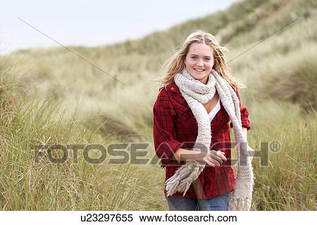 Teenage Girl Walking Through Sand Dunes Wearing Warm Clothing View Large Photo Image Stock Photography - Teenage Girl Walking Through Sand Dunes Wearing Warm Clothing. Fotosearch