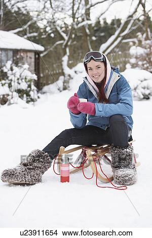 Picture - Teenage Girl With Sledge Next To Snowman With Flask And Hot Drink. Fotosearch