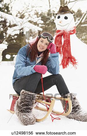 Teenage Girl With Sledge Next To Snowman View Large Photo Image Stock Photograph - Teenage Girl With Sledge Next To Snowman. Fotosearch