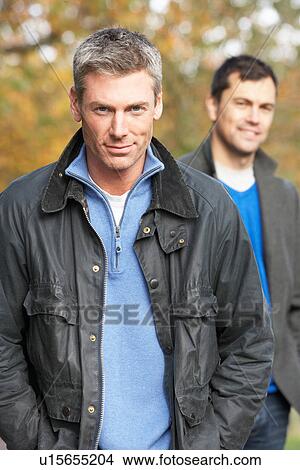 Picture - Two Men Standing Outside In Autumn Woodland. Fotosearch
