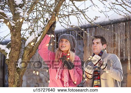 Two Teenage Girls Hanging Fairy Lights In Tree With Icicles In Foreground View Large Photo Image Stock Image - Two Teenage Girls Hanging Fairy Lights In Tree With Icicles In Foreground. Fotosearch
