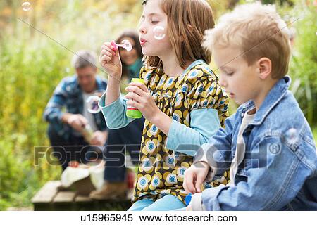 Two Young Children Blowing Bubbles On Countryside Picnic View Large Photo Image Stock Photography - Two Young Children Blowing Bubbles On Countryside Picnic. Fotosearch