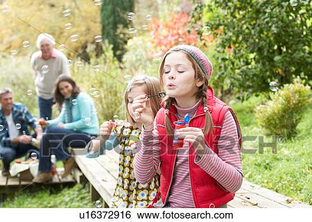 Two Young Girls Blowing Bubbles On Countryside Picnic View Large Photo Image Stock Photograph - Two Young Girls Blowing Bubbles On Countryside Picnic. Fotosearch