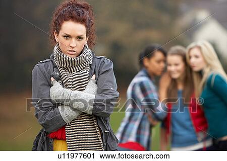 Upset Teenage Girl With Friends Gossiping In Background View Large Photo Image Stock Image - Upset Teenage Girl With Friends Gossiping In Background. Fotosearch