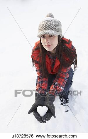 Stock Photograph - Woman Holding Heart Made Out Of Snow. Fotosearch