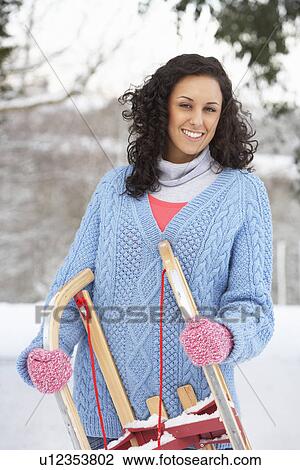 Stock Image - Woman Holding Sledge In Snowy Landscape. Fotosearch