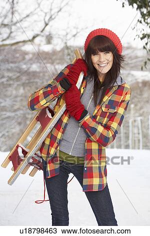 Stock Image - Woman Holding Sledge In Snowy Landscape. Fotosearch