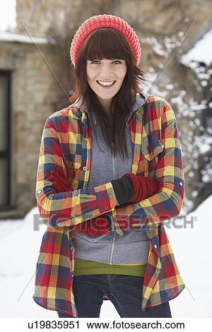 Stock Image - Woman In Snowy Landscape Wearing Warm Clothing. Fotosearch