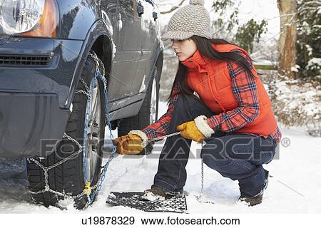 Woman Putting Snow Chains Onto Tyre Of Car View Large Photo Image Stock Photo - Woman Putting Snow Chains Onto Tyre Of Car. Fotosearch