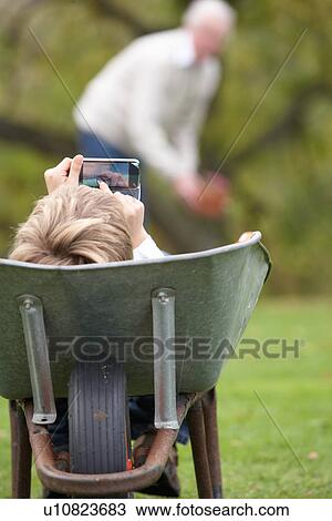 Young Boy Laying Wheelbarrow Using Smart Mobile Phone View Large Photo Image Stock Image - Young Boy Laying Wheelbarrow Using Smart Mobile Phone. Fotosearch