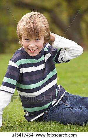 Young Boy Relaxing Outdoors Sitting On Grass View Large Photo Image Picture - Young Boy Relaxing Outdoors Sitting On Grass. Fotosearch