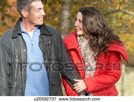 Stock Photo - Young Couple Walking Through Autumn Park. Fotosearch