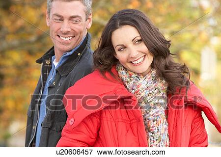 Stock Photo - Young Couple Walking Through Autumn Park. Fotosearch