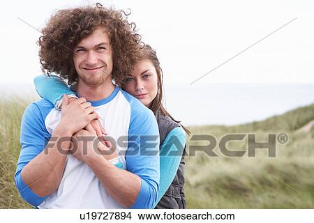 Young Couple Walking Through Sand Dunes Wearing Warm Clothing View Large Photo Image Picture - Young Couple Walking Through Sand Dunes Wearing Warm Clothing. Fotosearch