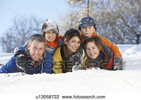 Stock Image - Young Family Having Fun In Snowy Landscape. Fotosearch