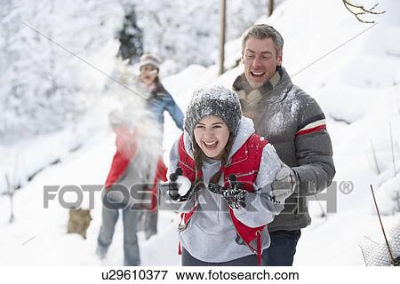 Stock Photo - Young Family Having Snowball Fight In Snowy Landscape. Fotosearch